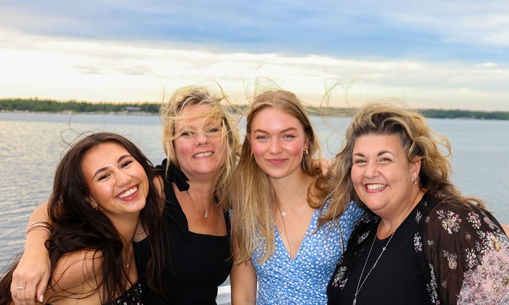 Photo of 4 Lakeland employees smiling in front of a lake