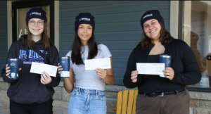 3 young students holding bursary cheques.