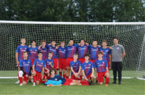 Muskoka's U17 Football Club dressed in Lakeland sponsored jerseys in front of soccer net.
