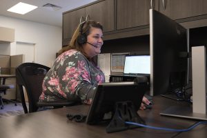 Lakeland customer service representative at computer and wearing a headset.