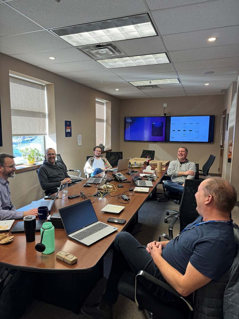 Lakeland staff at boardroom table talking and smiling.