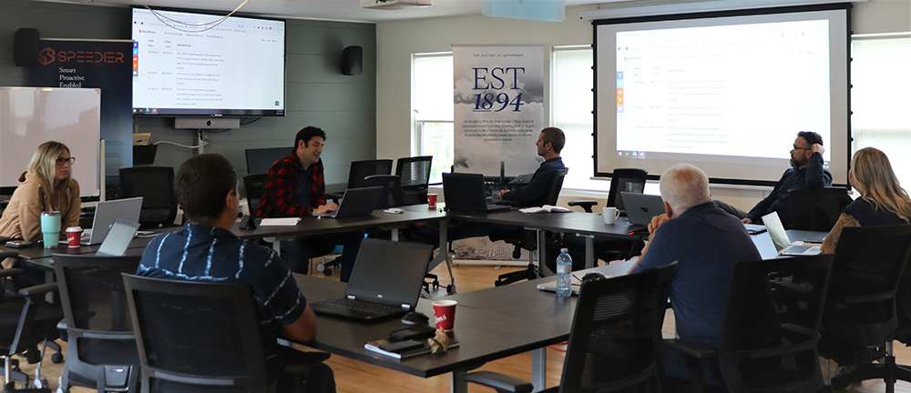 Lakeland team working together in a conference room with projectors on either wall.