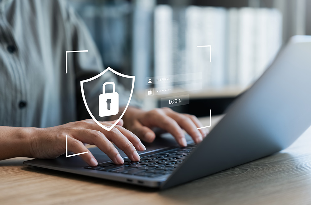 Closeup of hands on a laptop with a shield and lock icon superimposed
